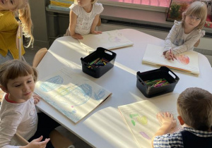 dzieci rysują historię głoski "o" w dedykowanych książkach